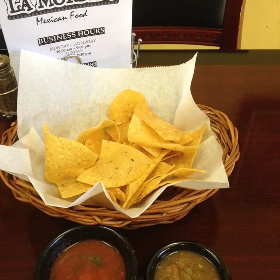 Basket of tortilla chips with red and green salsa at La Mordida Mexican Food restaurant.